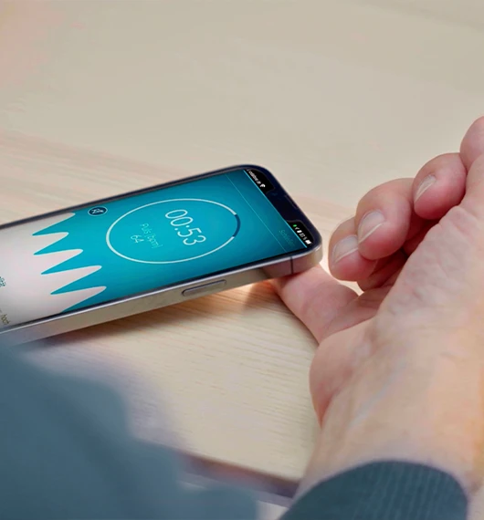 Person misst den Herzrhythmus mit der Preventicus App auf dem Smartphone