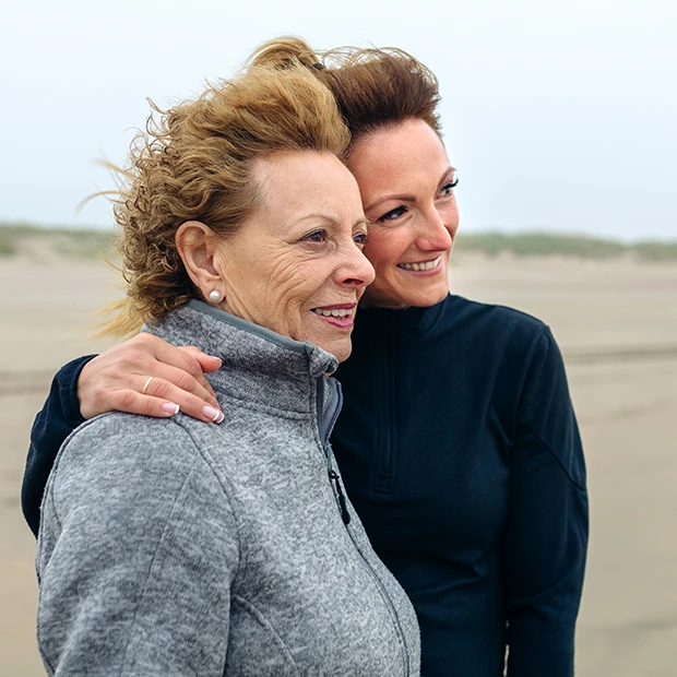 Zwei Frauen am Strand schauen gemeinsam in die Ferne