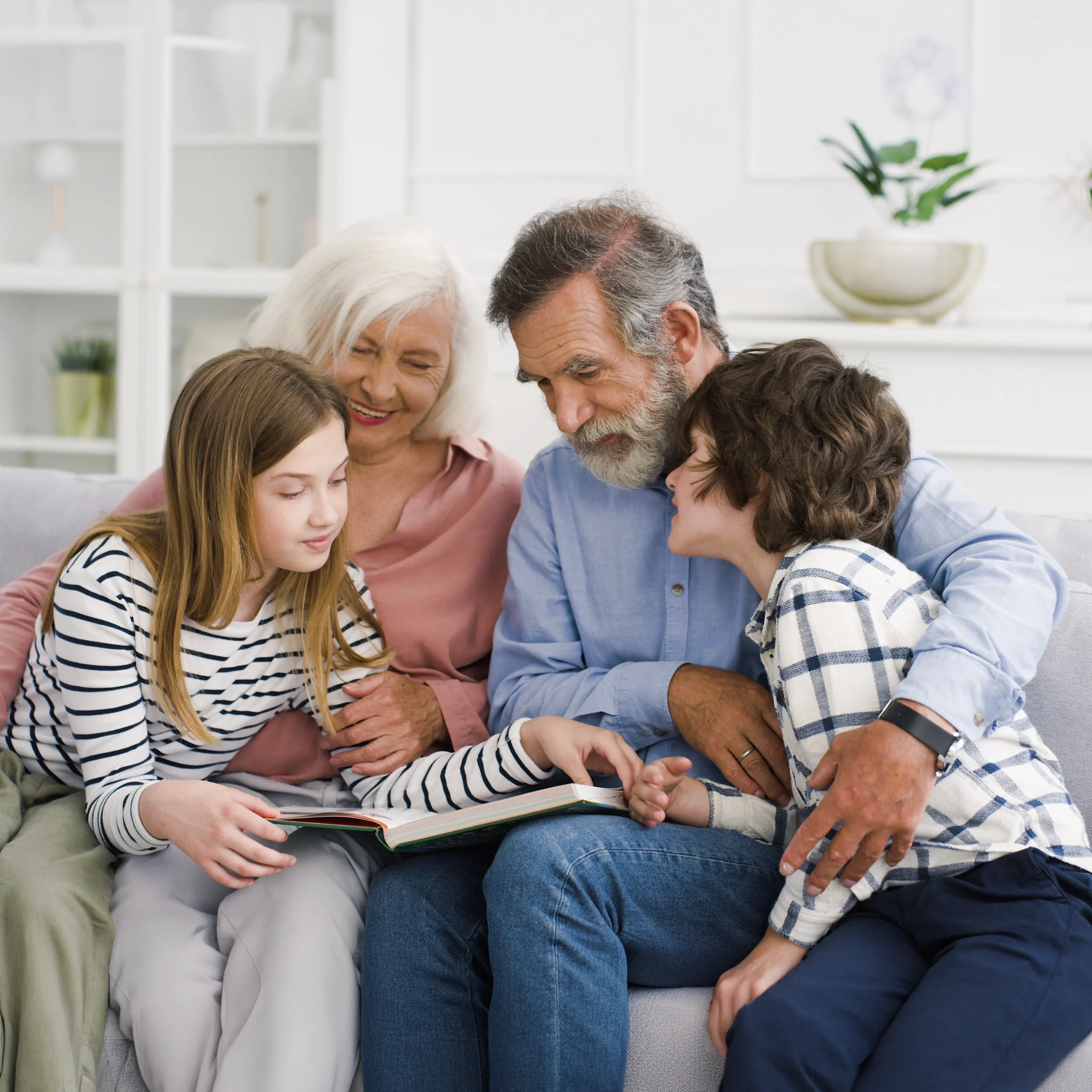 Großeltern lesen gemeinsam mit ihren Enkelkindern